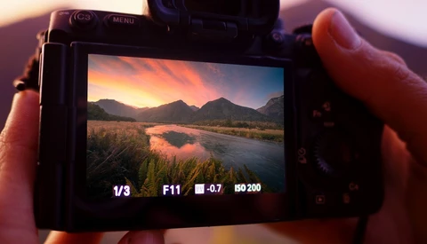 Camera LCD screen displaying landscape photo with exposure settings: 1/3 shutter speed, F11 aperture, -0.7 exposure compensation, ISO 200.