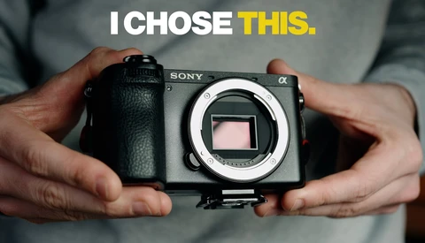 Sony Alpha mirrorless camera body held in hands, showing the sensor and lens mount.