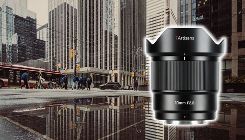 Artisans 10mm f2.8 ultra-wide lens product shot displayed over urban street reflection