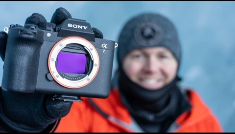 Sony a7 mirrorless camera with sensor visible, held up to display purple filter coating.