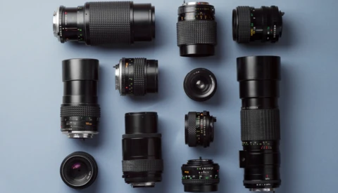Collection of vintage camera lenses arranged symmetrically on a light blue background