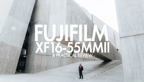 Title card for Fujifilm XF16-55mm II lens review overlaid on modern architecture with lone figure.