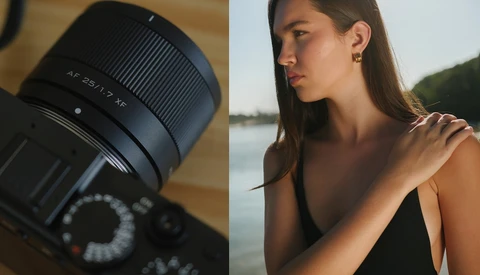 Sony lens with f/2.8 aperture mounted on camera body next to portrait of woman by water.