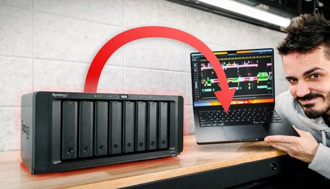 Man pointing to laptop displaying music production software connected to external hard drive array.
