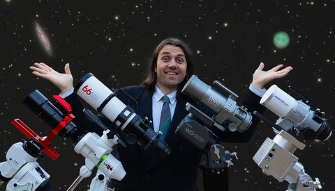 Man in business attire surrounded by various telephoto lenses and camera equipment against a starry background.