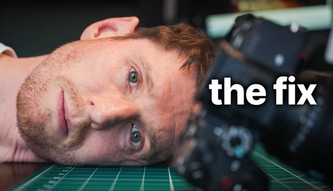 Man lying on desk with camera gear, looking at camera with tired expression labeled 'the fix.'