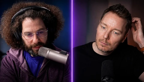 Two male podcast hosts seated at microphones during a recording session with purple lighting dividing the frame.