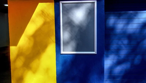 Abstract color field composition with yellow, dark blue, and neutral tones divided by geometric planes