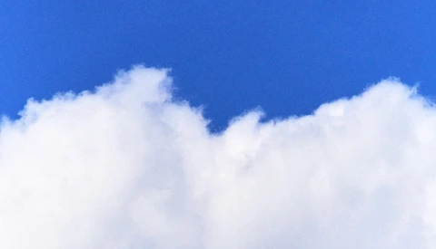 Puffy white cumulus clouds against a vibrant blue sky