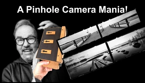 Enthusiast holding a wooden pinhole camera with sample black and white photographs displayed
