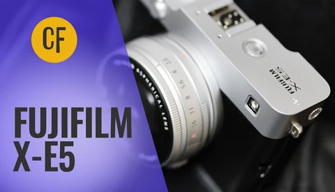 Fujifilm X-E5 mirrorless camera with interchangeable lens against purple and black background