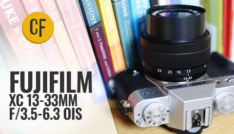 Fujifilm XC 13-33mm f/3.5-6.3 OIS lens mounted on silver mirrorless camera body with books in background