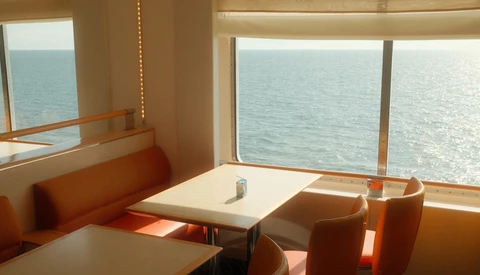 Modern interior with orange seating and expansive ocean views through floor-to-ceiling windows