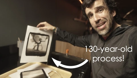Photographer holding a vintage print or negative showing a 130-year-old photographic process