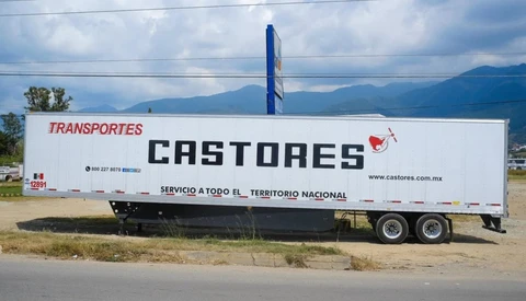 White commercial transport truck with 'Castores' branding parked against mountain landscape