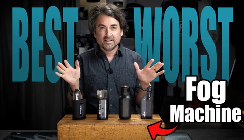 Man gesturing toward fog machines displayed on wooden table with text overlay reading 'BEST WORST Fog Machine'