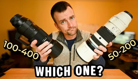 Photographer comparing two telephoto lenses labeled 100-400 and 50-200 against an orange background