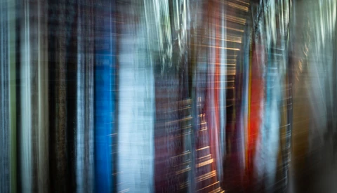 Vertical motion blur of tall buildings with red, blue, and warm-toned glass facades