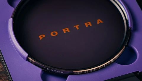 Portra film stock container displayed on purple surface with dramatic lighting