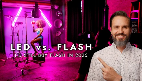 Man in light shirt pointing at studio setup with magenta LED neon lighting and professional flash equipment