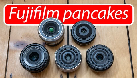 Five Fujifilm pancake lenses arranged on wooden surface with red text overlay