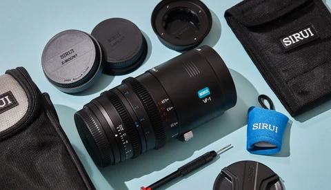 SIRUI lens and accessories laid out on light blue background with carrying cases and lens caps