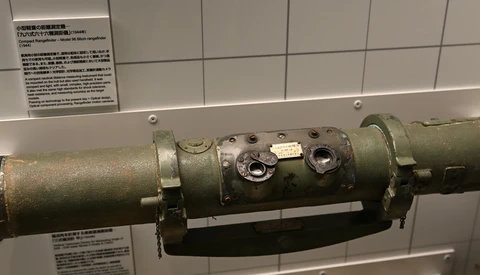 Military rocket launcher or missile system with olive drab cylindrical tubes mounted on display
