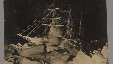 Sailing ship trapped in pack ice under starry night sky