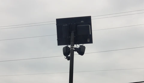 LED light panel mounted on a pole against a cloudy sky