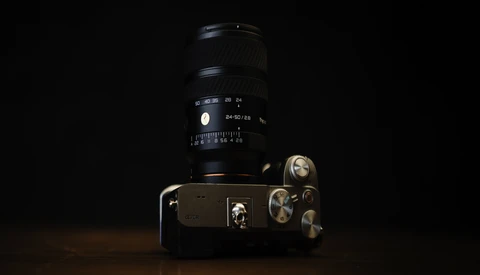 Vintage film SLR camera with telephoto lens against black background, studio lighting