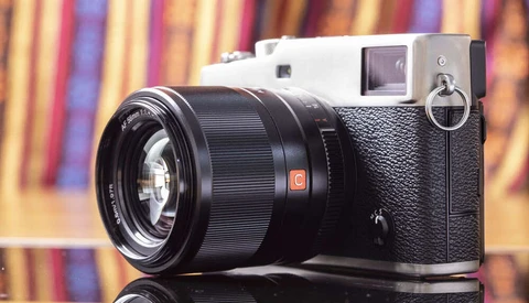 Rangefinder camera with black lens on colorful striped background