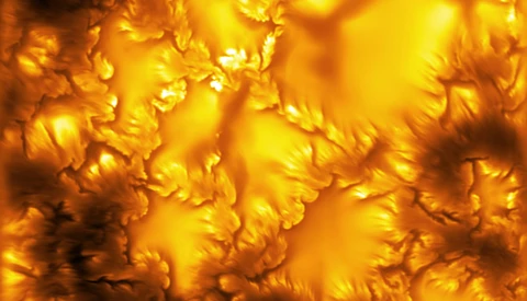 Abstract close-up of liquid gold or molten metal with turbulent, flowing surfaces and warm highlights