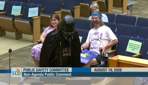 Person in Darth Vader costume speaking at Public Safety Committee meeting podium