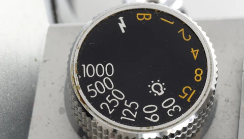 Close-up of camera aperture dial with f-stop numbers and shutter speed markings