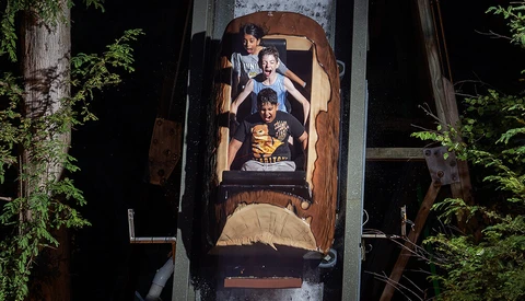 Overhead shot of four people on an amusement park ride captured from directly above