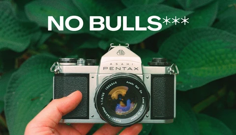 Pentax film camera held in hand with text overlay reading 'NO BULLS***'