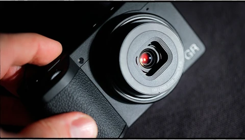 Handheld gimbal stabilizer with red indicator light held in photographer's hand
