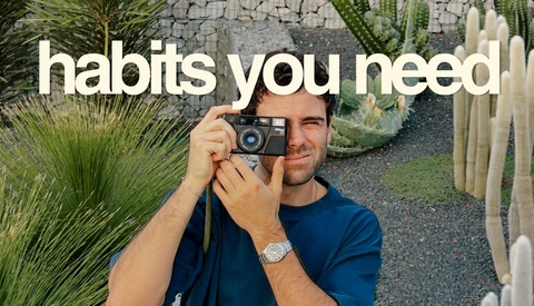 Photographer holding vintage film camera with succulents and desert plants in background