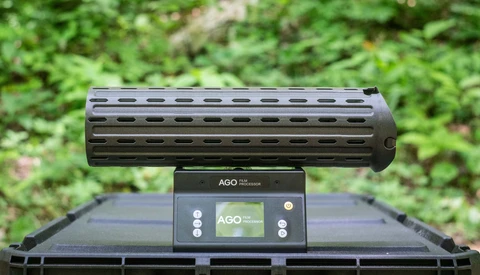 AGO gun rail system mounted on black tactical handguard with green foliage background