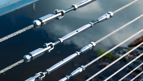 Close-up of stainless steel turnbuckles and tensioned cables on boat rigging