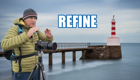 Photographer in yellow jacket with telephoto lens on tripod at seaside lighthouse