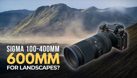 Nikon camera with Sigma 100-400mm lens positioned on mountainous landscape with volcanic peaks and mist