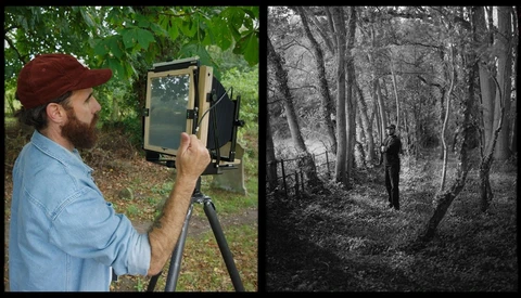 Photographer using large format camera on tripod in forest setting