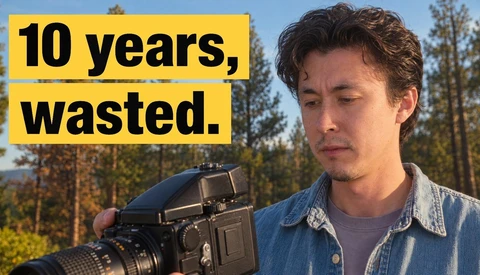 Photographer holding a medium format film camera with a contemplative expression outdoors