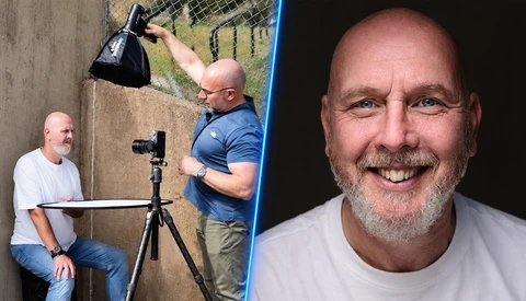 Photographer adjusting studio lighting setup while another person operates camera on tripod