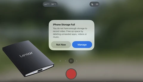 Phone camera screen showing an iPhone Storage Full alert next to a black Lexar portable SSD in the foreground