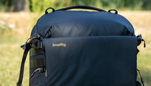 SmallRig backpack with padded compartment displayed outdoors against blurred green background