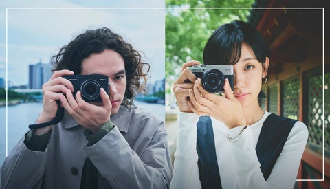 Two photographers holding rangefinder cameras, side-by-side comparison portrait