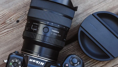 Tamron lens with lens cap and camera body on wooden surface