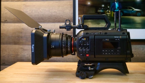 Blackmagic cinema camera with SmallRig matte box and 24mm cine lens mounted on a wooden table